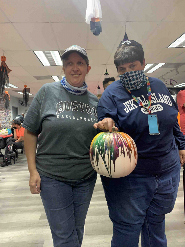 2 members with decorated pumpkin